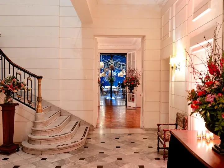 Hall principal con escalera de mármol y baranda de fierro forjado