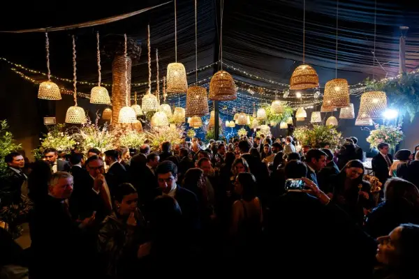 Fiesta bajo la carpa iluminada con lámparas de mimbre