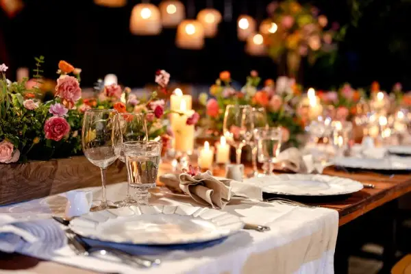 Detalle de mesa con vajilla, copas, flores y velas
